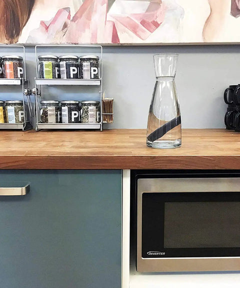 Charcoal Water Purifying Stick from Kishu Japan for crisp, better-tasting water in glass carafe on kitchen counter