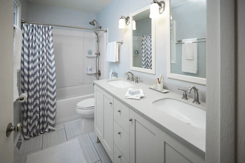 Bathroom with Bancroft Single Sconce with Frosted Glass Shade, brushed nickel finish, above double sinks, sleek modern design.