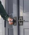 Person opening door with Latitude Lever With Collins Trim Non Turning Dummy Door Handle Dope Matte Black For Right Or Left Swing Doors