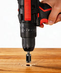Hand using an electric drill with a wood plug cutter bit on a wooden surface, demonstrating Eight Piece Wood Plug Cutter Drill Bit Set Delivering Smooth As Butter Coverage For Furniture Maintenance And Trim Repairs.