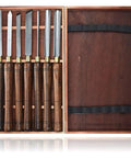 Dead Simple Wood Chisel Set Built Insanely Tough With High Carbon Steel Blades For Quick Wood Carving And Lathe Turning An Absolute Must Have Carpenter Gear Pack Kept Safe Inside A Classic Wooden Toolbox, featuring five chisels with wooden handles.