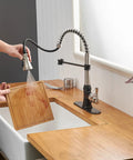 Person using Dual Finish Kitchen Faucet In Black And Brushed Nickel With Pull Down Sprayer And Three Spray Modes Single Handle