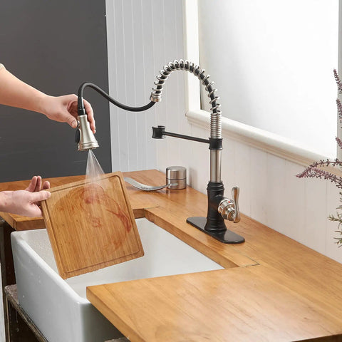 Person using Dual Finish Kitchen Faucet In Black And Brushed Nickel With Pull Down Sprayer And Three Spray Modes Single Handle
