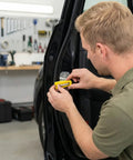 Man installing Door Lock Shock Absorber Pads 4 Pack Red Rubber Noise Dampening Bumpers for cars with adhesive backing.