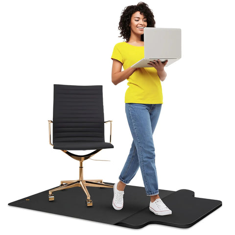 Two In One Standing Desk Floor Mat With Anti Fatigue Cushioned Footrest For Hardwood Floors Dual Zone Design For Standing Comfort And Smooth Chair Rolling Large 54 By 36 Inches Office Mat, depicted with chair and person using laptop.