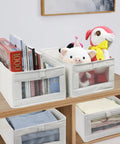 4 Pack Linen Storage Bins With See Through Window For Closet Organization showing books, toys, and folded jeans on a shelf
