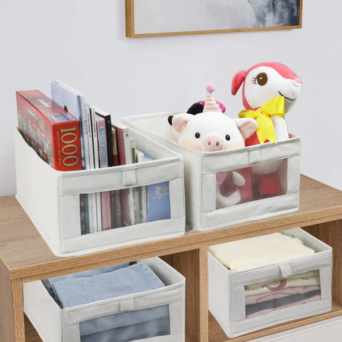 4 Pack Linen Storage Bins With See Through Window For Closet Organization showing books, toys, and folded jeans on a shelf