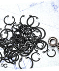 Elastic Circlip Bearing Clips Set Assorted Retaining Rings Kit with Metal Snap Rings and Bearings on a Blueprint