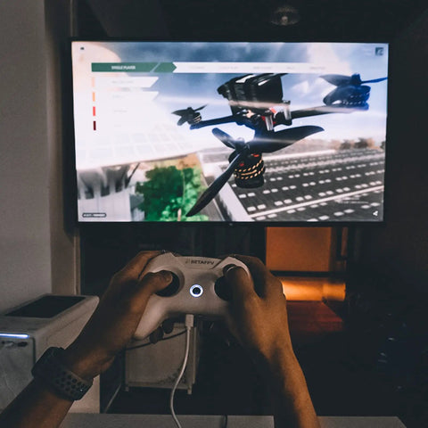 Person using FrSky D16 LiteRadio 2 SE Transmitter For FPV Drones, USB C Charging, for simulator on a screen.