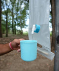 Pouring water into a cup from Trail Ready Dish Set With Mesh Bag BPA Free Durable Lightweight Polypropylene Eating Utensils