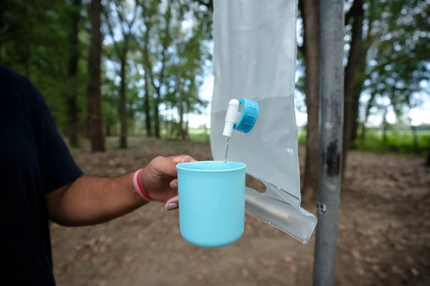 Pouring water into a cup from Trail Ready Dish Set With Mesh Bag BPA Free Durable Lightweight Polypropylene Eating Utensils