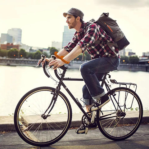 Cyclist wearing 24 Piece Bicycle Theme Motivational Silicone Wristbands Set For Parties BMX Vibes riding by the river.
