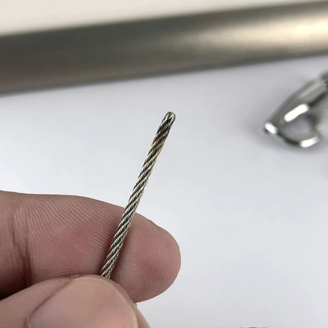 Close-up of steel cable from Click Rail Picture Hanging System Kit with Two White 59 Inch Rails Four Steel Cables Six Hooks Four End Caps