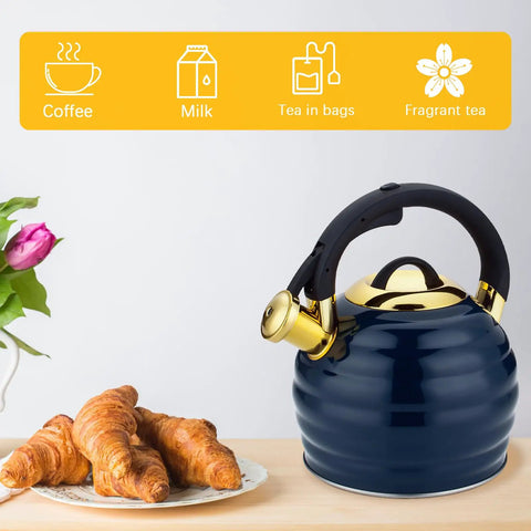 Stovetop Whistling Tea Kettle 3.2 Quart Stainless Steel Teakettle With Heat Proof Ergonomic Handle next to croissants on a table.