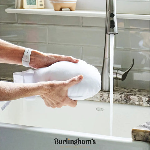 Person washing Double Security Mitts For Hand Restraint In Healthcare With Extra Padding under running water at a sink.