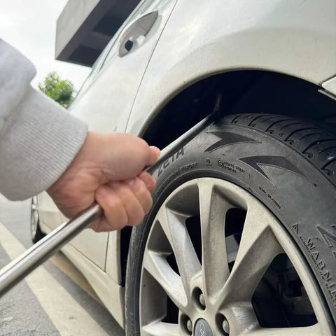 Using Beast 91-Piece Paintless Dent Repair Kit rod on car wheel arch for dent removal.