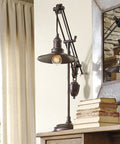 Urban Industrial 29.5 Inch Metal Desk Lamp With Adjustable Arm And Shade Bronze Finish next to vintage books against a window