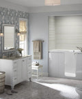 Devonshire Style Wall Sconce Bath Vanity Light With Frosted Glass Shade, Brushed Nickel Finish next to vanity in elegant bathroom