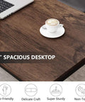 Close-up view of 47 Inch Modern Rustic Computer Desk With Metal Legs And Adjustable Feet, featuring a wooden top and coffee cup.