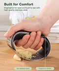 Hand using Garlic Press Rocker Stainless Steel Crusher Mincer and Chopper with Peeler and Scraper for effortless garlic crushing
