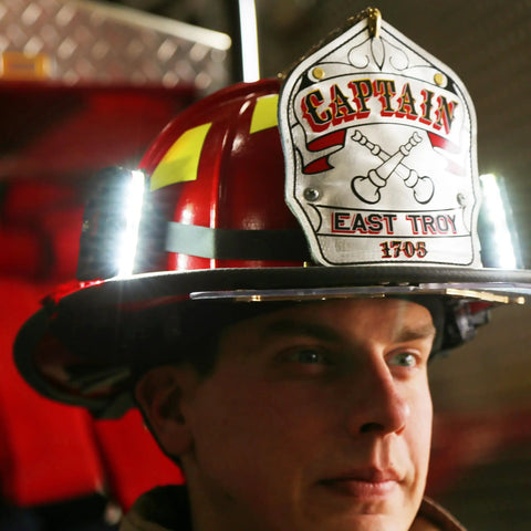 Firefighter wearing Helmet Strap Mount Accessory With Two Magnetic Mounts And Screw In Feature For Hard Hats And Fire Safety Helmets
