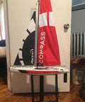 53 Inch Remote Control Sailboat Kit With Pre Assembled Sail Accessories, standing indoors with red and black canvas sails.