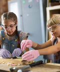 Kids using pink and purple cut-resistant gloves for crafting, demonstrating Kids Cut Resistant Gloves Level 5 Four Pairs Pack In Bright Colors For Kitchen Prep Garden Work Oyster Shucking Craft Projects And DIY Safety Flexible Grip Small Size For Young Cooks And Makers Kid Tested.