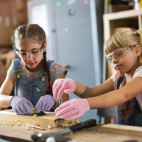 Kids using pink and purple cut-resistant gloves for crafting, demonstrating Kids Cut Resistant Gloves Level 5 Four Pairs Pack In Bright Colors For Kitchen Prep Garden Work Oyster Shucking Craft Projects And DIY Safety Flexible Grip Small Size For Young Cooks And Makers Kid Tested.