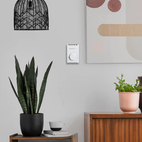 Manual 4 Wire Line Voltage Baseboard Thermostat For Electric Heaters No Frills mounted on wall near decor