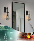 Black Raindrop Glass Wall Sconce With On Off Switch Sleek Modern Vanity Light Fixture in a bathroom setting, highlighting lamp detail.