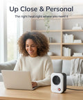 Woman using laptop with MyHeat Personal Space Heater Under Desk, Compact White, 200 Watt Office Foot Warmer on a desk in a cozy room.