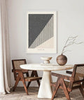 Modern dining area featuring abstract art print, round marble table, wooden chairs, and decorative vase.