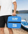 Man holding Insulated Cooling Pack for Seaside Adventures and Water Sports next to paddleboard on a sunny beach.
