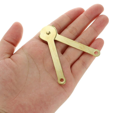 Gold Metal Lid Stay Hinge 2.7x0.3 Inches held in hand, showing compact size and gold finish, from Six Pack Durable Rust Resistant Lid Support Hinge series