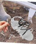 Lawn Aerator Shoes With Heavy Duty Metal Spikes 5.8 CM Set Of 20 Pegs shown with hand holding a peg and soil background