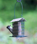 Rustic Black Metal Suet Cage Feeder For Outdoor Bird Watching, Hanging Bird Feeder With One Suet Cake Capacity in garden setting