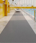 Hella Tough Non Slip Pvc Floor Mat cuttable poolside runner 3 by 35 feet in gray, placed alongside a swimming pool.