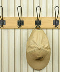 Super Sturdy Wall Mounted Coat Rack With Four Heavy Duty Hooks To Keep Clutter In Check, holding a hat on a natural wood background.