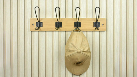 Super Sturdy Wall Mounted Coat Rack With Four Heavy Duty Hooks To Keep Clutter In Check, holding a hat on a natural wood background.