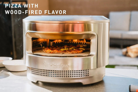 Pizza Oven Starter Bundle With Stainless Steel Outdoor Pizza Maker And Wood Fired Assembly on table with pizza inside