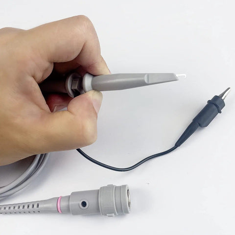 Hand holding 100MHz Oscilloscope Probe Kit With BNC Clip Probes Attenuation Adjustable 1x Or 10x, showing detachable hook tip.