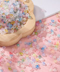Acrylic Frosted Flower Beads Six Millimeter With Golden Speckles Matte Mini Floral Spacer Beads Bulk 1000pcs scattered on a surface