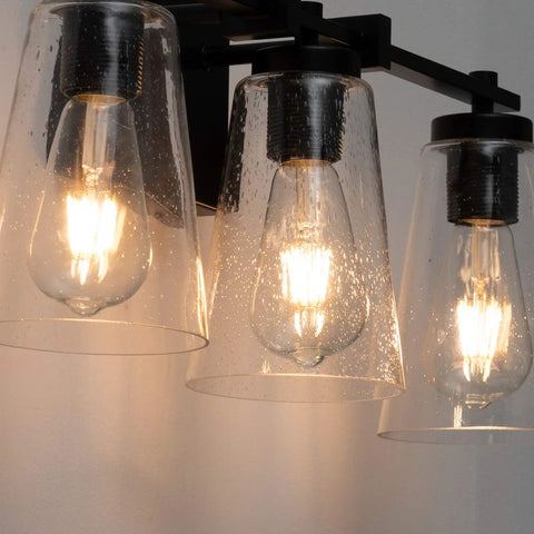 Close-up of Vintage Industrial 3 Light Vanity Sconce In Black With Bubble Glass Shades, highlighting filament bulbs.