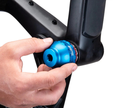 Hand using Blue Anodized Bottom Bracket And Pedal Tool With Laser Engraving, 3/8 Drive, 44mm, 16 Notch Socket on bicycle