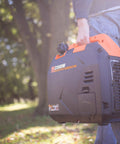 Person carrying Ultra Quiet 2350 Watt Portable Inverter Generator With Fuel Shutoff Gas Powered Lightweight 39 Pound Unit in park