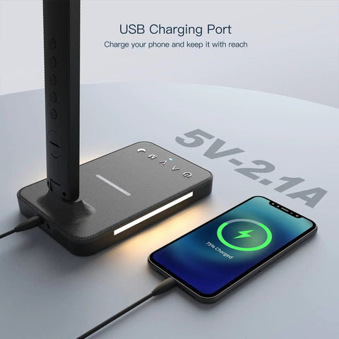 Close-up of LED desk lamp with wireless charger, USB port showing 5V-2.1A, and phone charging on pad.