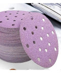 Kick Ass 6 Inch Sanding Discs With 17 Holes For Fast Dust Extraction Hook And Loop Backing That Sticks Tight stacked on a work surface.