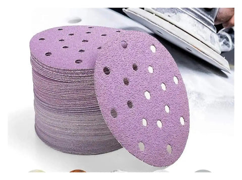 Kick Ass 6 Inch Sanding Discs With 17 Holes For Fast Dust Extraction Hook And Loop Backing That Sticks Tight stacked on a work surface.