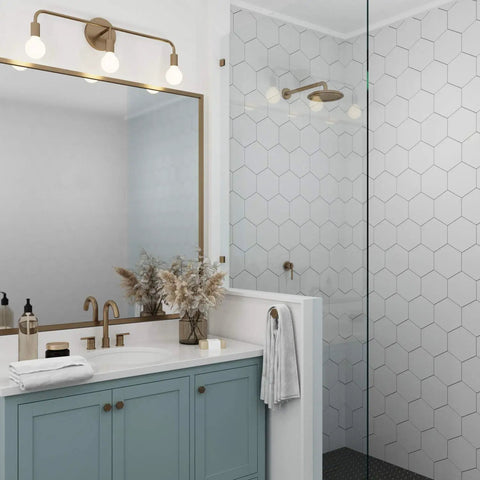 Brass Three Light Vanity Wall Fixture For A Modern Farmhouse Bathroom Vibe, 24 Inch Wide, above a vanity in bathroom setting