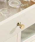 Close-up of Champagne Bronze Cabinet Knobs 10 Pack Modern Drawer Pulls on white kitchen cabinet drawer with glassware